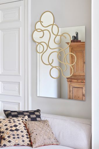 Twirl Gold irregular wall mirror styled in an interior, highlighting irregular-shaped decorative mirror.